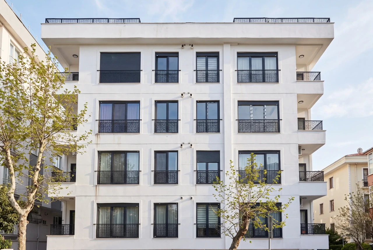 Zeynep Azra Apartmanı, İdealtepe; beyaz cephe, siyah doğramalar ve dekoratif metal balkon korkulukları